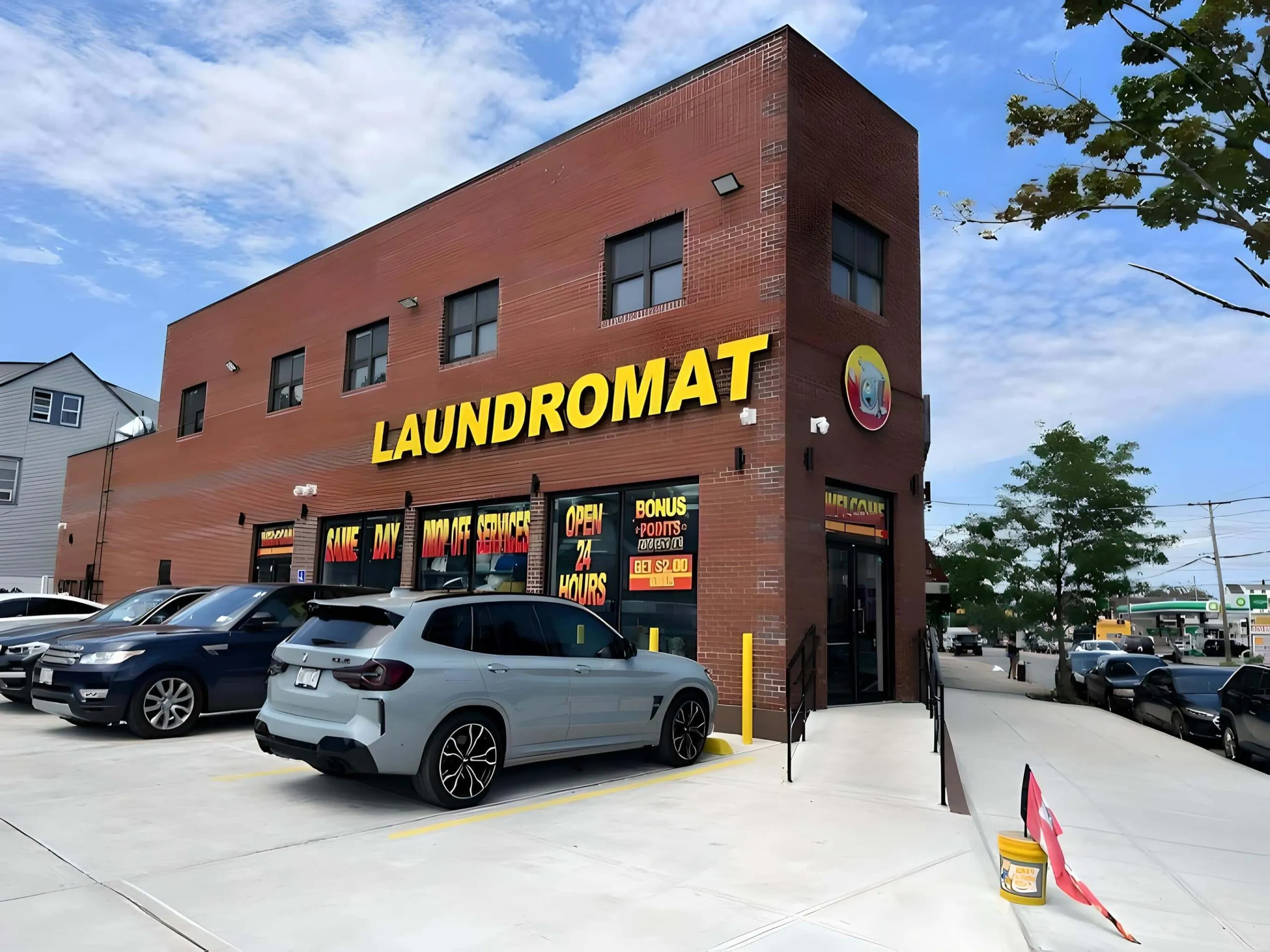 Farmers Laundromat's red-brick corner building on Farmers Blvd with its yellow LAUNDROMAT sign