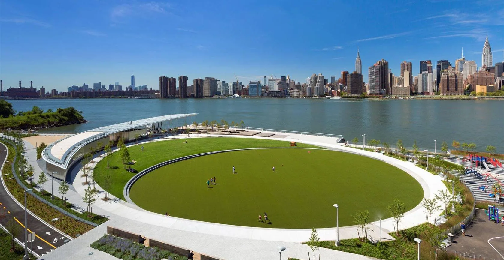 Hunters Point South waterfront park and its oval lawn, with the Manhattan skyline across the East River