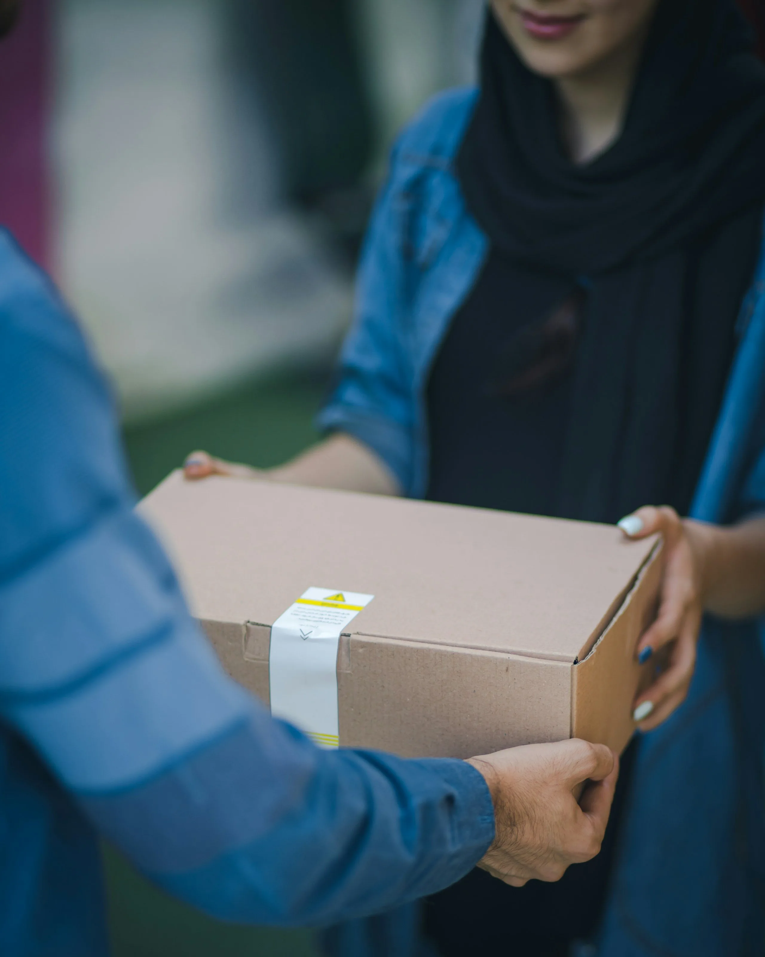A boxed prescription order handed to a patient at her door