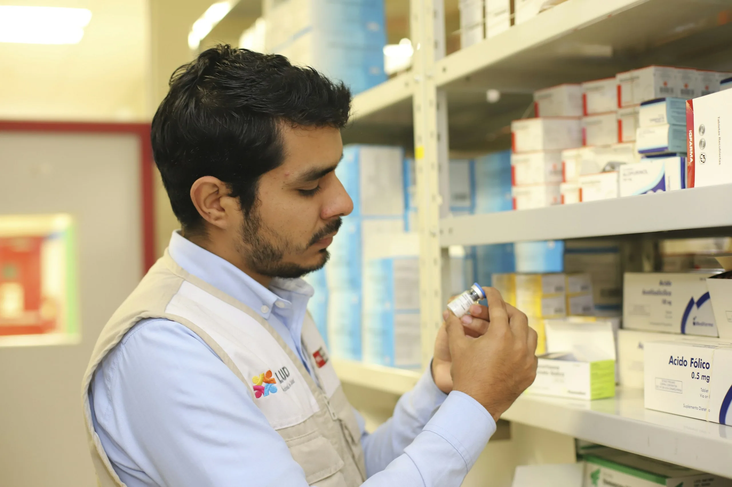 Pharmacist reading the label on a medication bottle