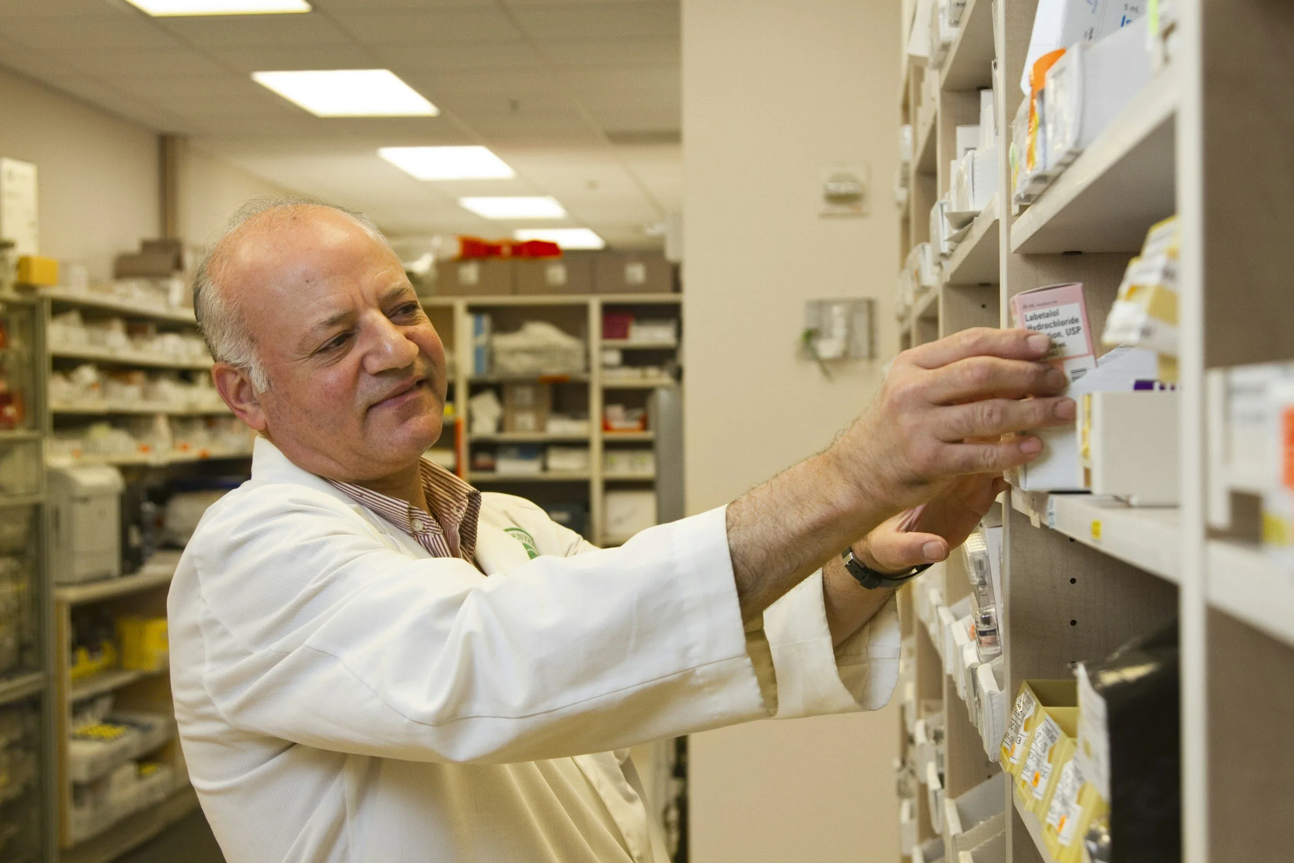 Pharmacist checking stock on the pharmacy shelves