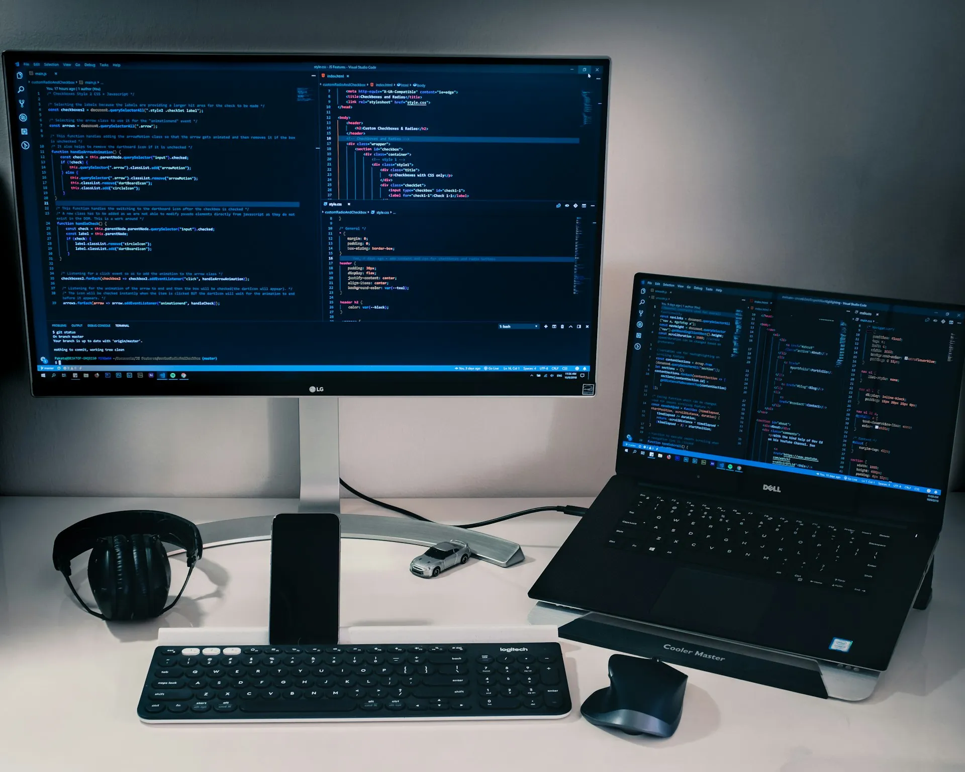 Workstation with a desktop monitor and laptop showing code