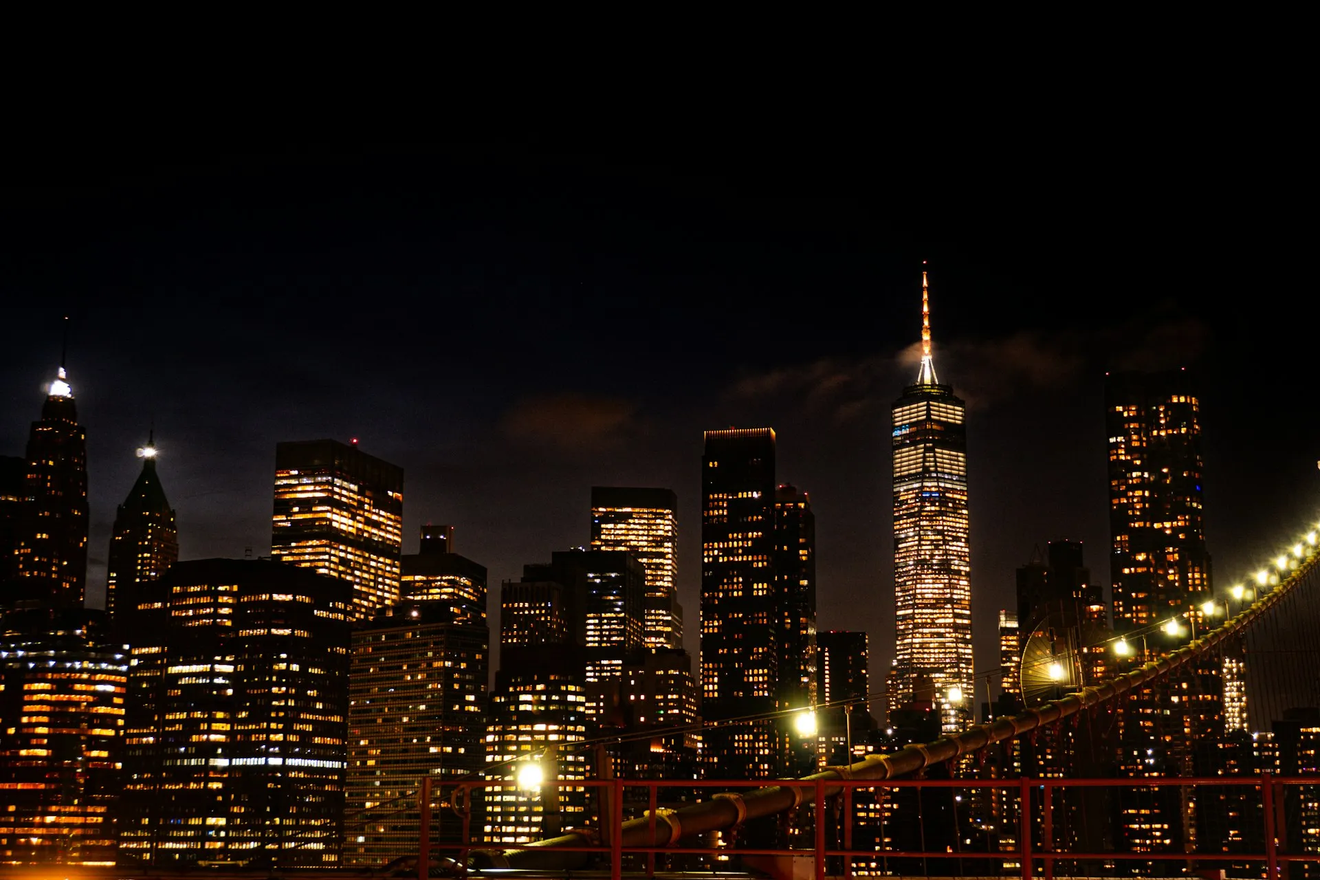 Lower Manhattan at night from the Brooklyn Bridge — devices managed wherever work happens