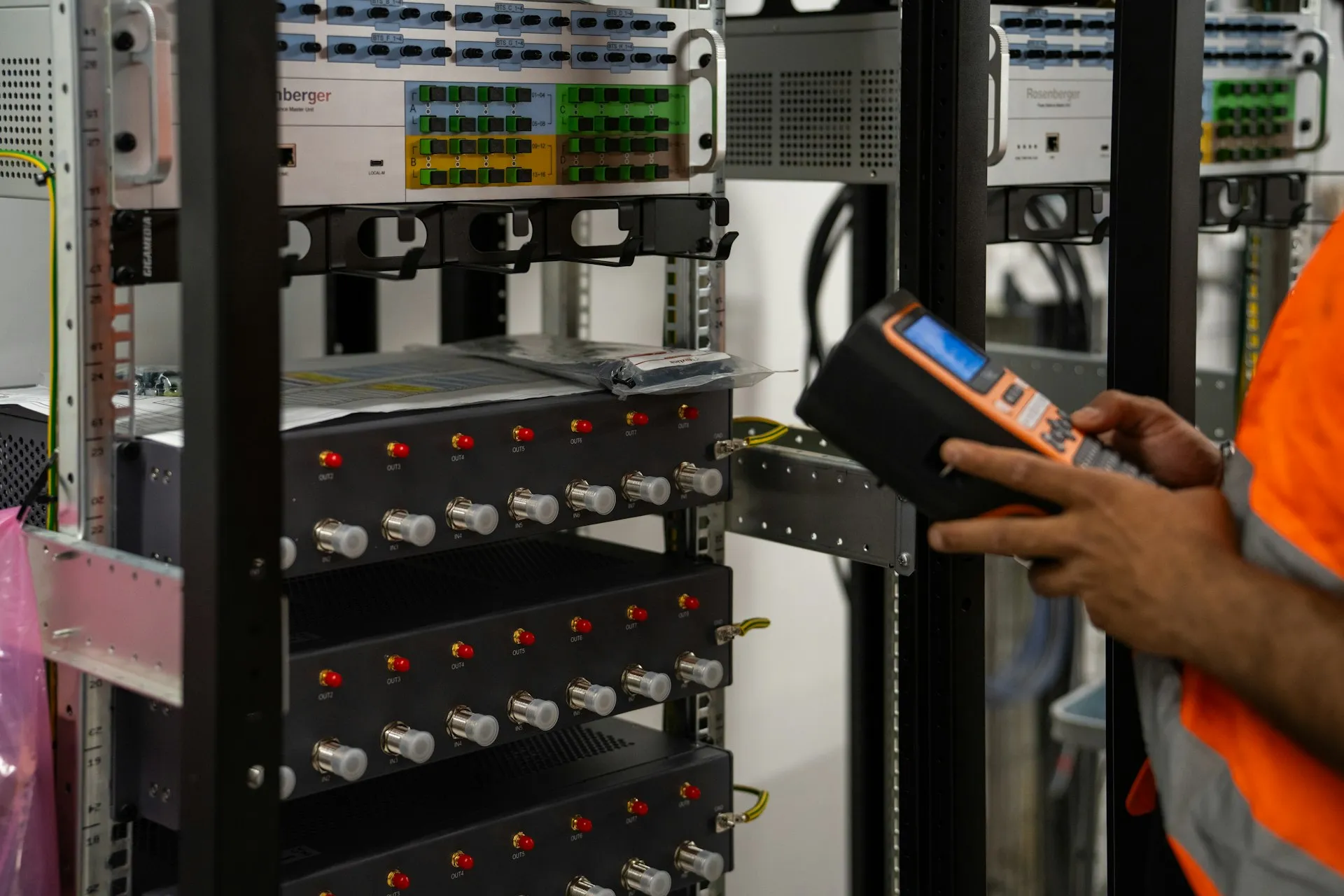 Technician testing server room equipment with a handheld meter