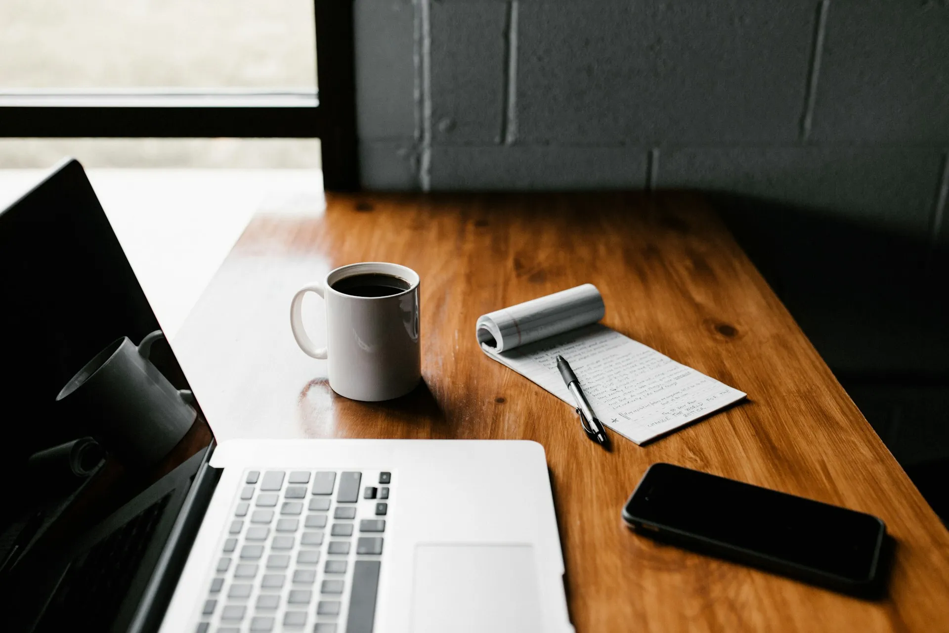 Laptop, notepad and phone on an office desk
