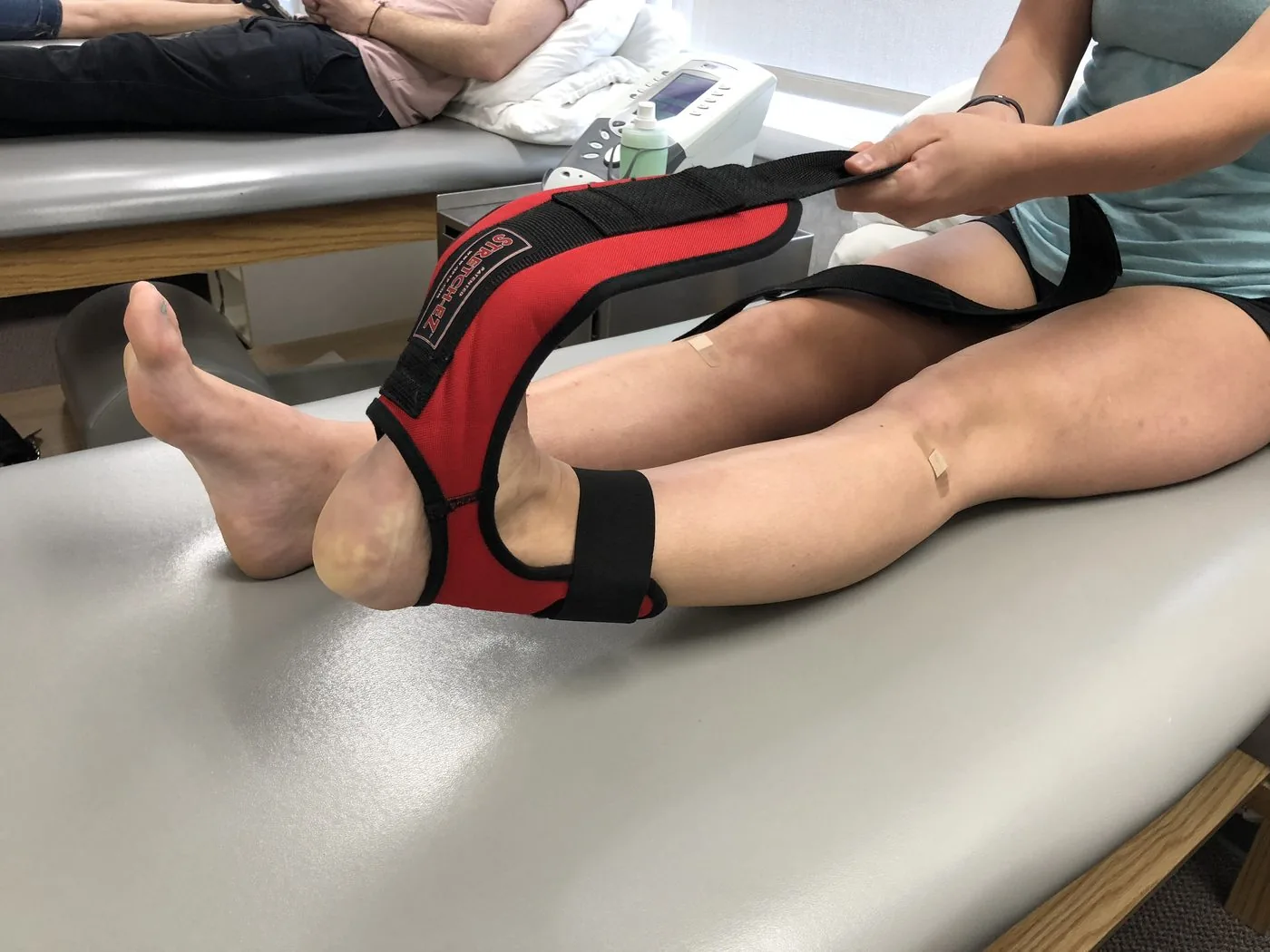 Patient using a leg stretching strap